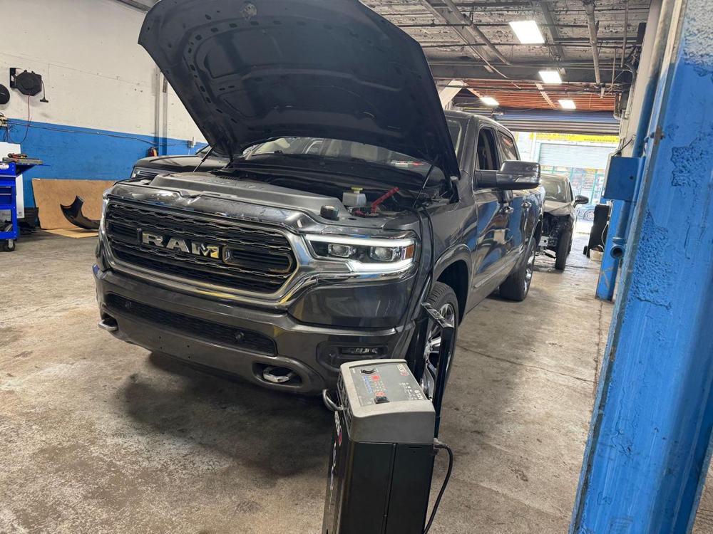 Ram 1500 with hood open connected to shop equipment